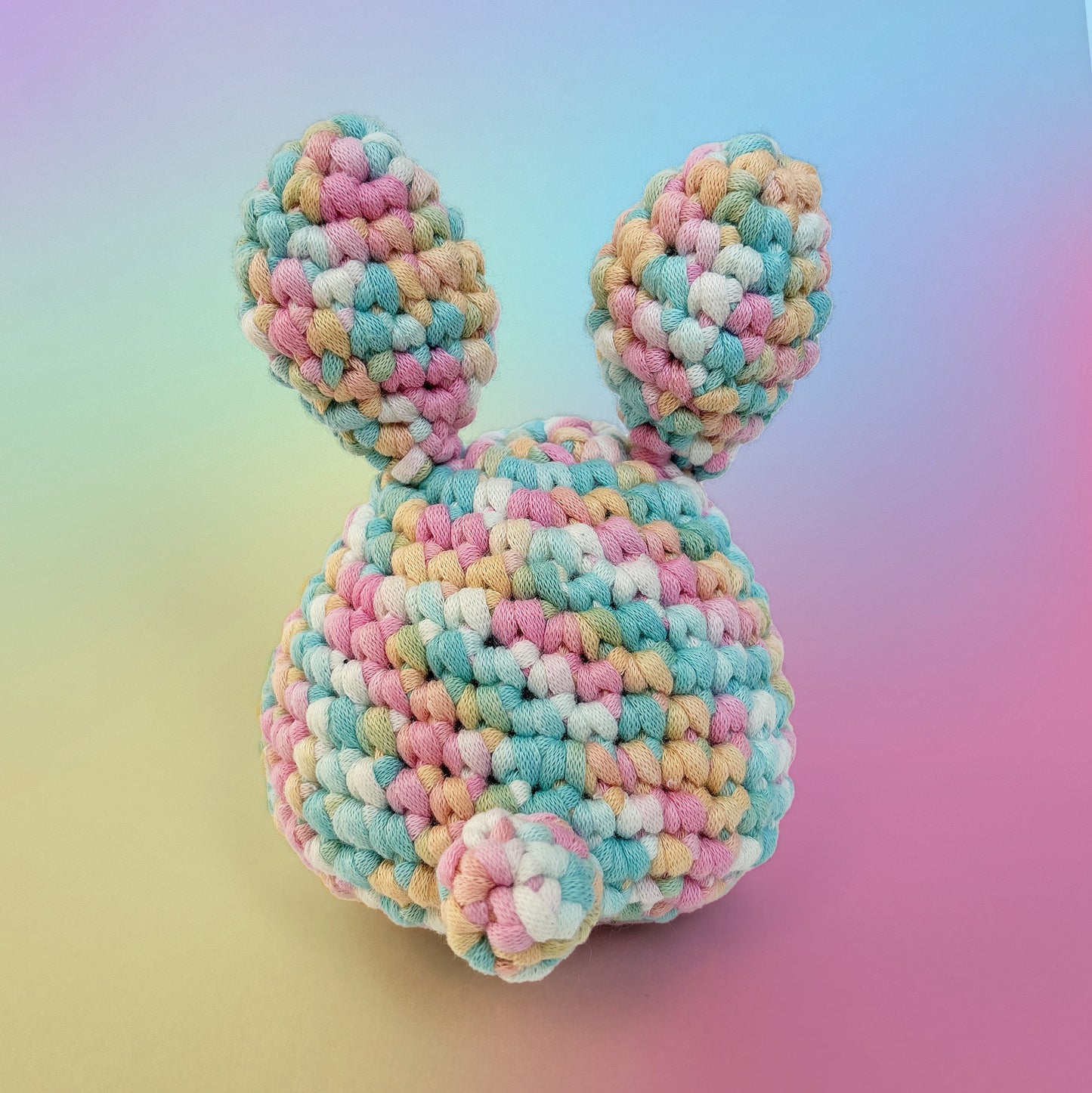 Bunny crochet amigurumi from rainbow pastel yarn, handmade from our beginner crochet kit. Perfect as a handmade gifts for friends. Back view.