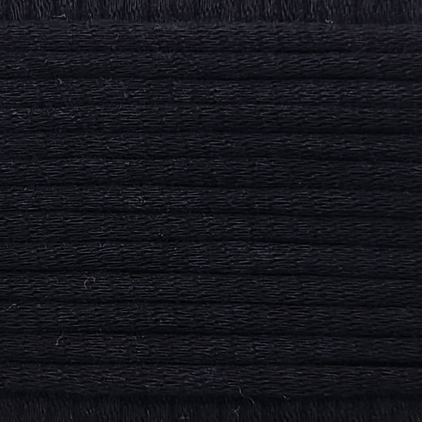 A close-up image showing the texture of a deep black coloured yarn that is friendly for crochet beginners.
