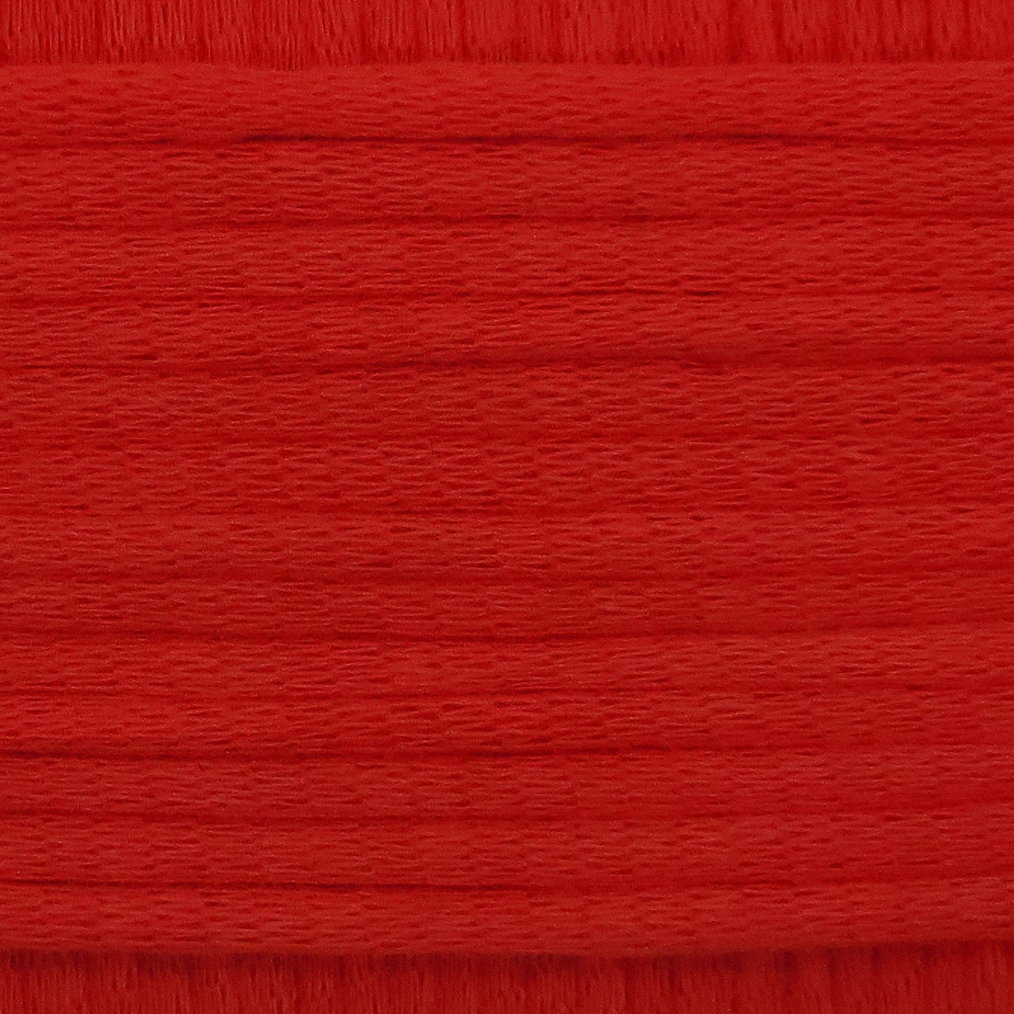 A close-up image showing the texture of a chilli red coloured yarn that is friendly for crochet beginners.