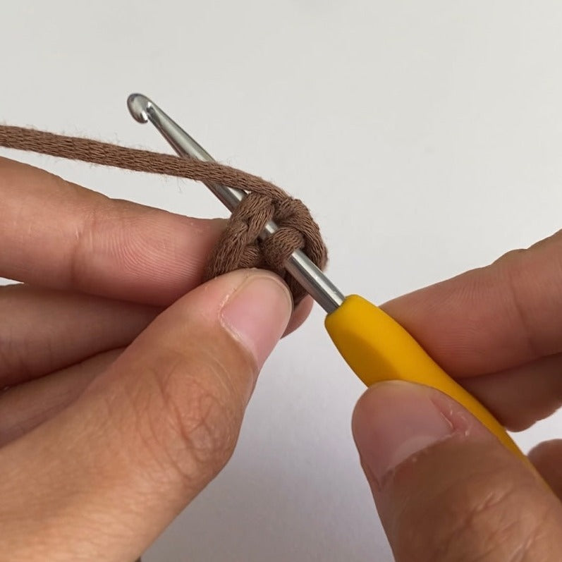A pair of hands crocheting using a 3.5mm ergonomic crochet hook.