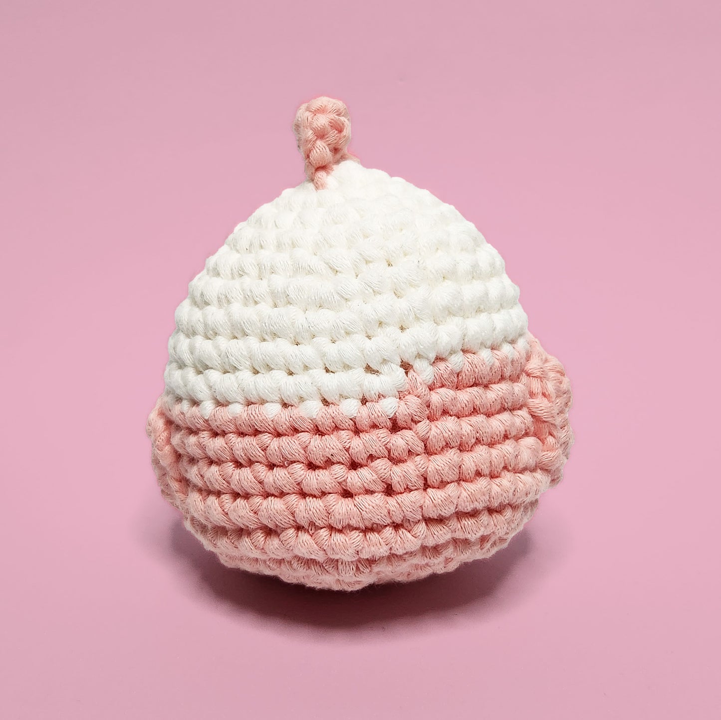 Pink and white lovebird crochet amigurumi with a cute feather accent. Handcrafted from our beginner-friendly crochet kit, ideal for those eager to learn crocheting. Back view.