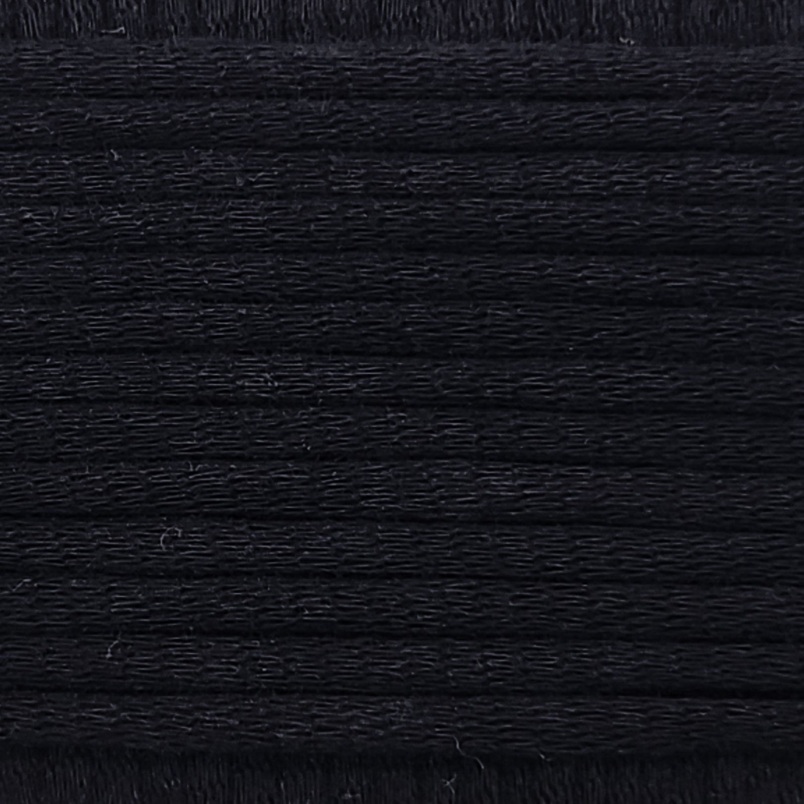 A close-up image showing the texture of a deep black coloured yarn that is friendly for crochet beginners.