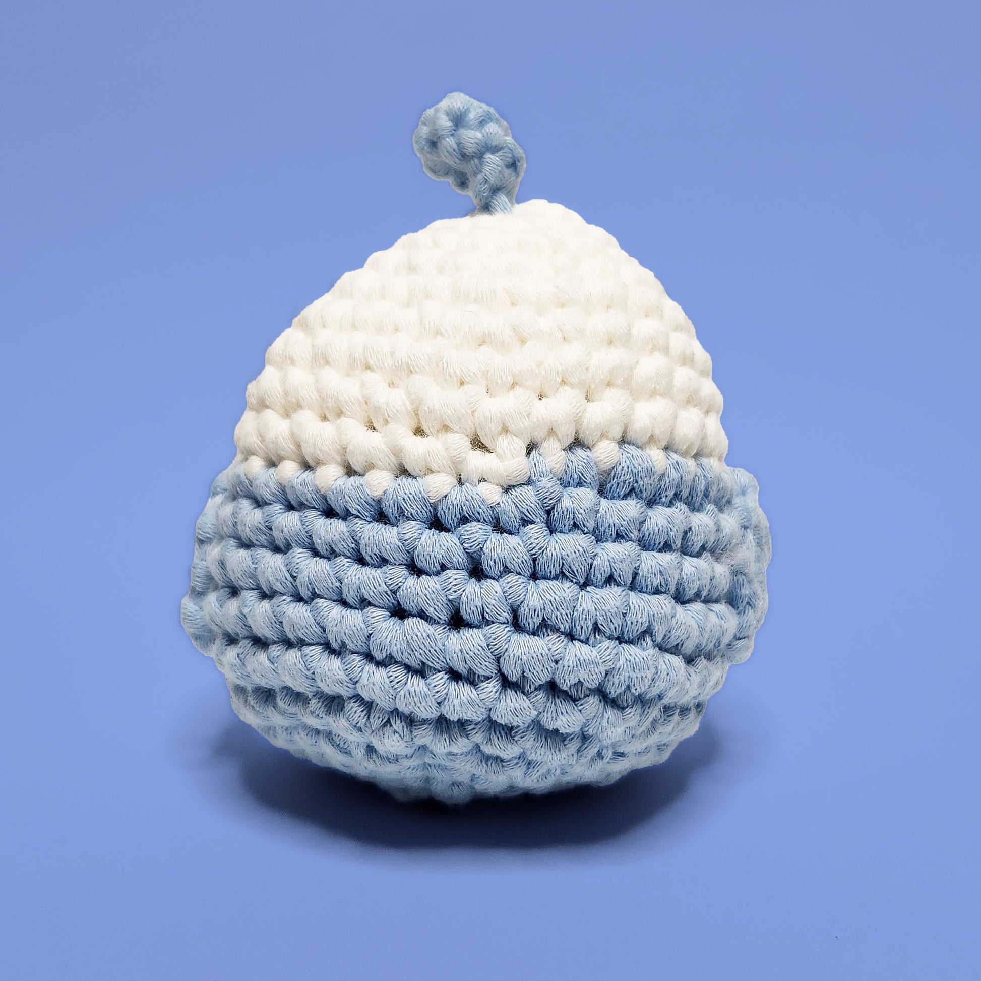 Blue and white lovebird crochet amigurumi with a cute feather accent. Handcrafted from our beginner-friendly crochet kit, ideal for those eager to learn crocheting. Back view.