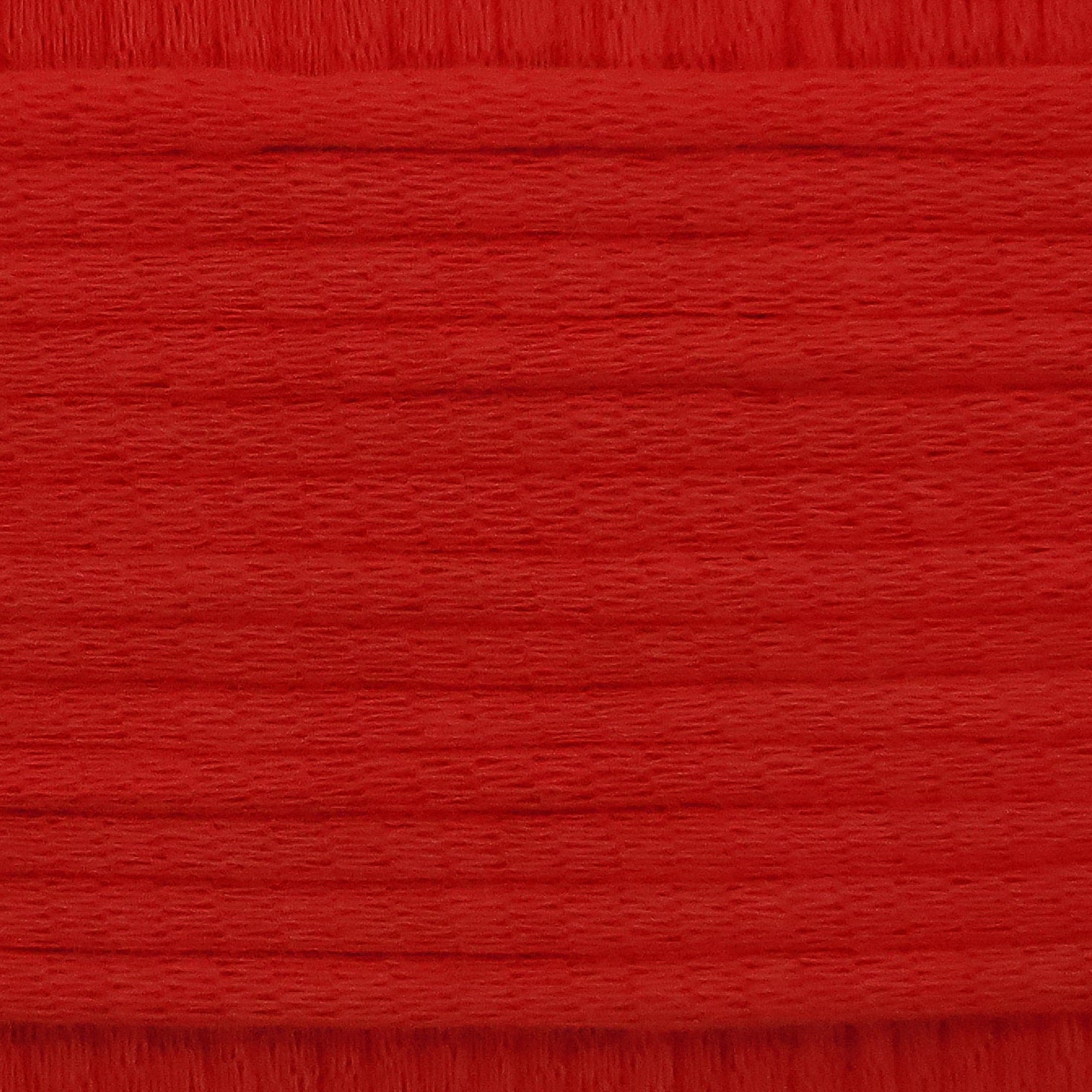 A close-up image showing the texture of a chilli red coloured yarn that is friendly for crochet beginners.