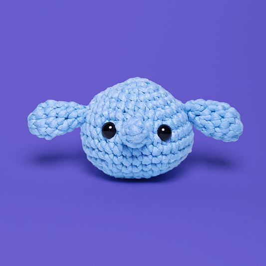 Blue crochet amigurumi elephant head, with long ears at the side. Made from our beginner-friendly crochet kit, ideal for beginners looking to learn crocheting. Front view.