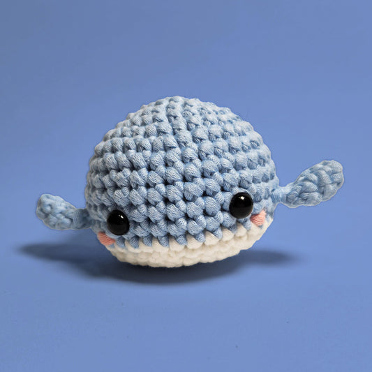 Blue and white amigurumi whale, handcrafted with care. Made from our beginner-friendly crochet kit, perfect for those new to crocheting. Front view.