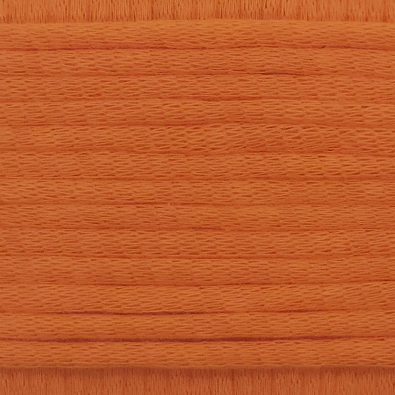 A close-up image showing the texture of a fire orange coloured yarn that is friendly for crochet beginners.