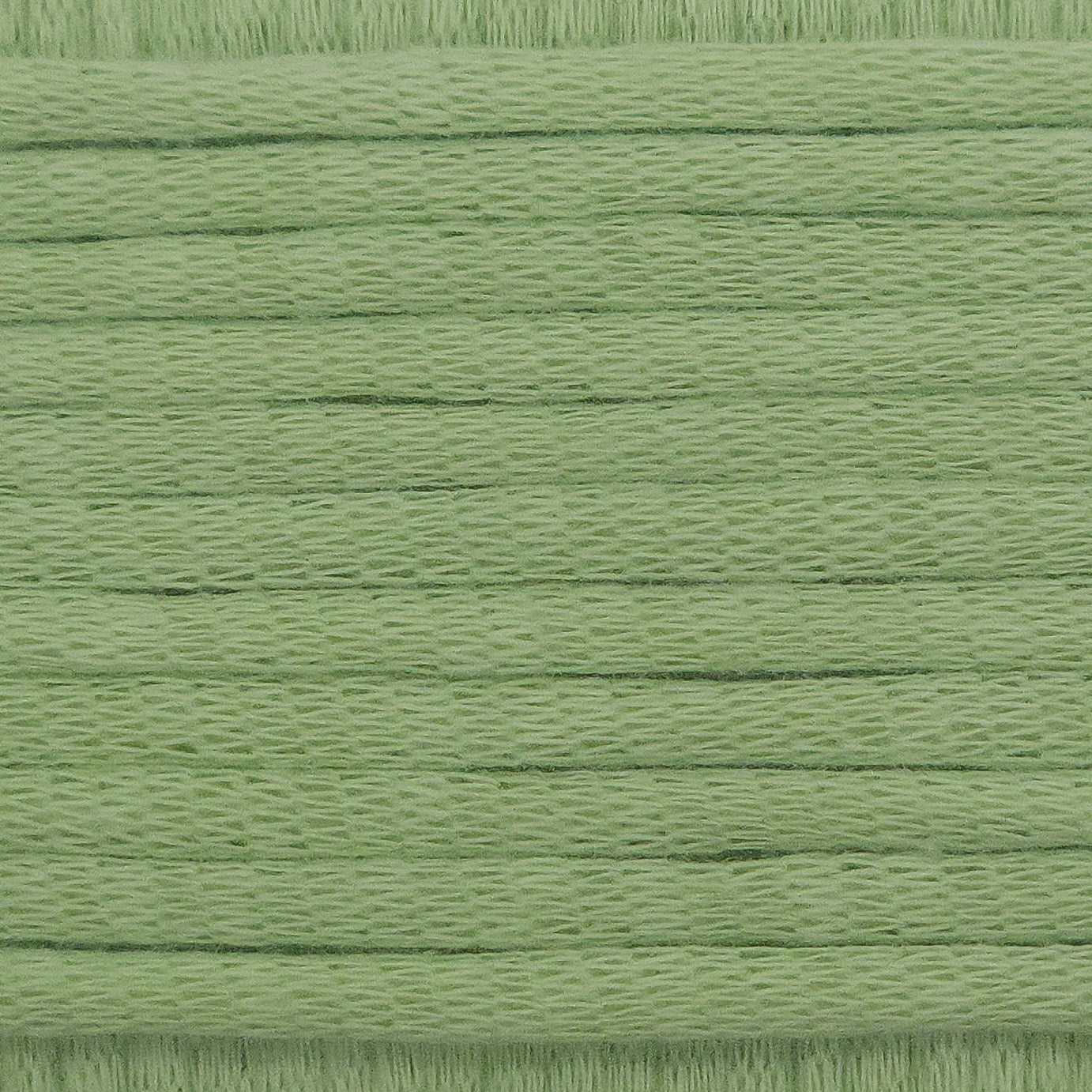 A close-up image showing the texture of a matcha green coloured yarn that is friendly for crochet beginners.