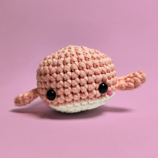 Pink and white amigurumi whale, handcrafted with care and attention to detail. Made from our beginner-friendly crochet kit, perfect for those new to crocheting. Front view.