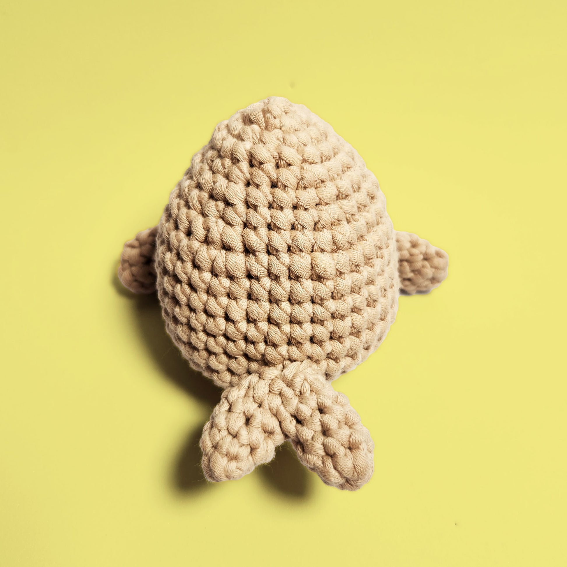 Brown seal crochet amigurumi, crafted using our beginner friendly crochet kit. This adorable seal features a realistic brown hue, perfect for animal lovers and crochet enthusiasts. Back view.