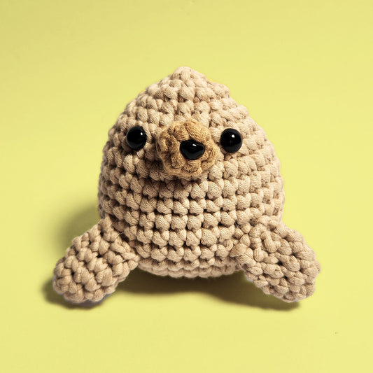 Brown seal crochet amigurumi, crafted using our beginner friendly crochet kit. This adorable seal features a realistic brown hue, perfect for animal lovers and crochet enthusiasts. Front view.