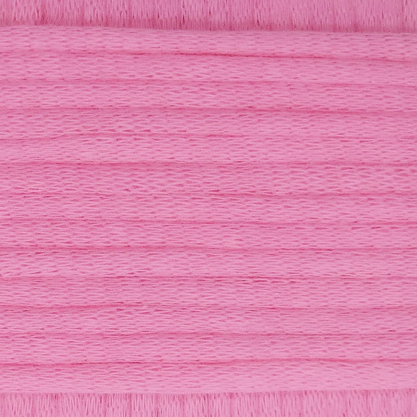 A close-up image showing the texture of a summer pink coloured yarn that is friendly for crochet beginners.