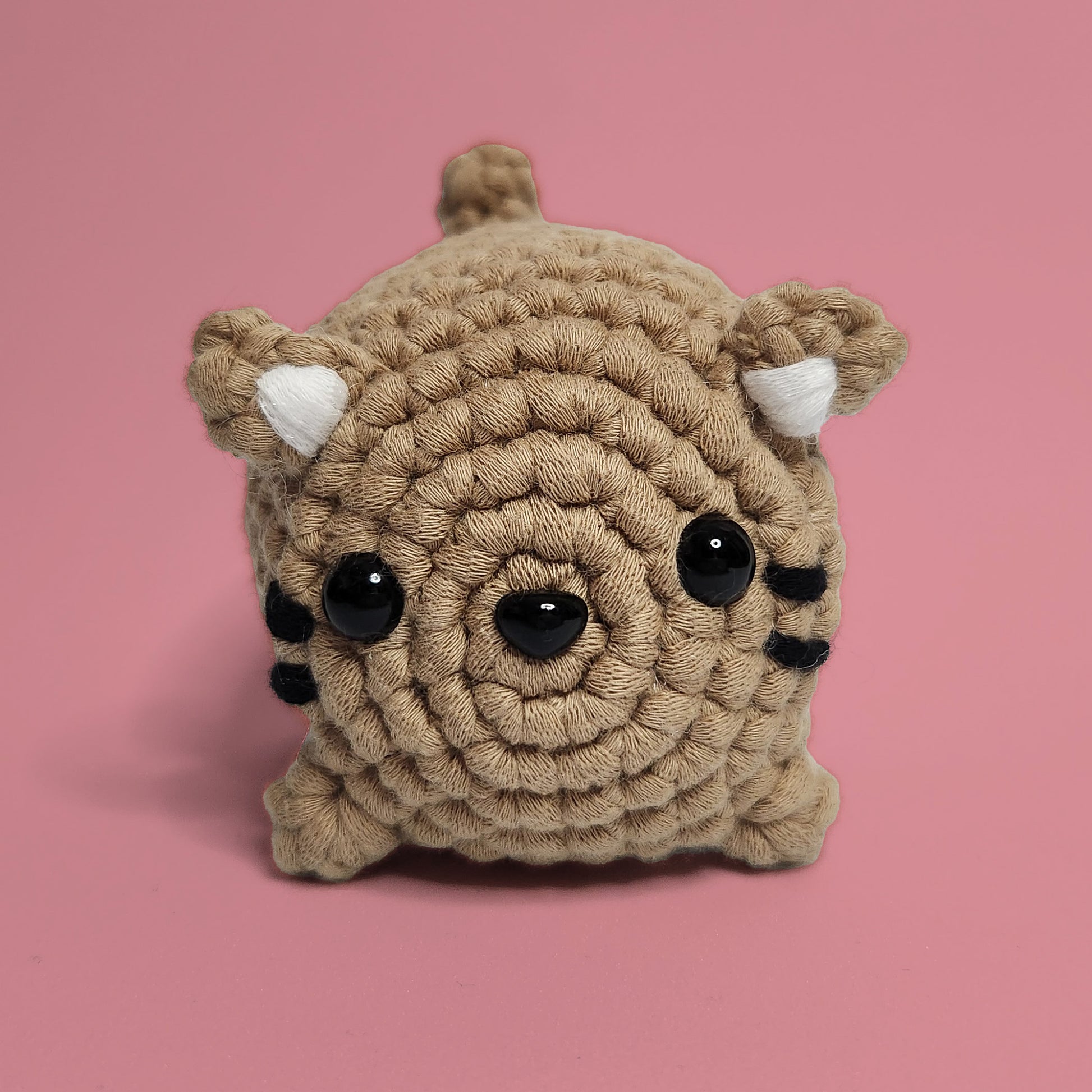 Brown cat crochet amigurumi with whiskers and ears. Handcrafted with care, this charming cat is a purr-fect project for cat lovers and crochet enthusiasts. Front view.