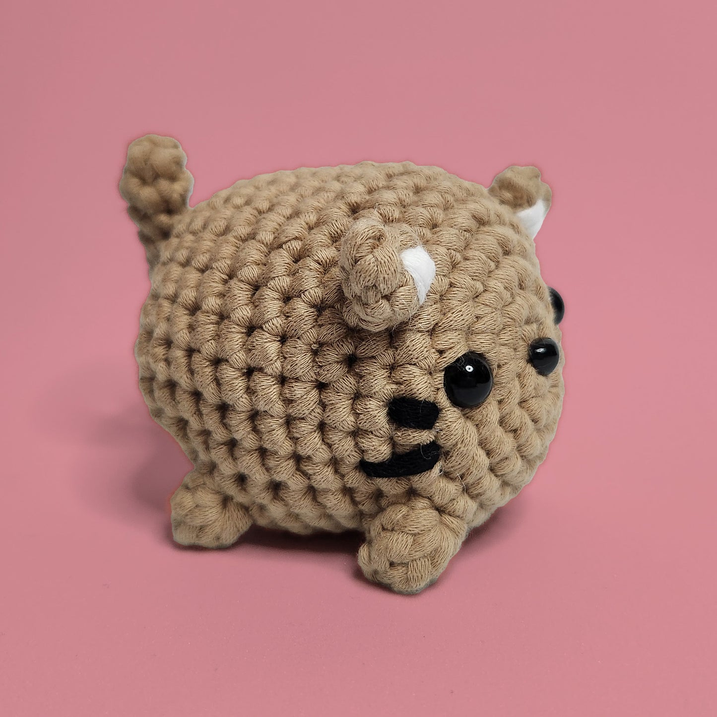 Brown cat crochet amigurumi with whiskers and ears. Handcrafted with care, this charming cat is a purr-fect project for cat lovers and crochet enthusiasts. Side view.